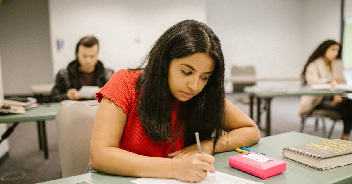 An IIT JEE aspirant studying with a focused mind, using a timetable and reference books in a well-organized study space.