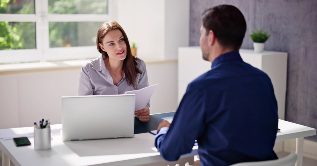 A confident professional shaking hands with an employer after successfully negotiating a salary during a job interview.