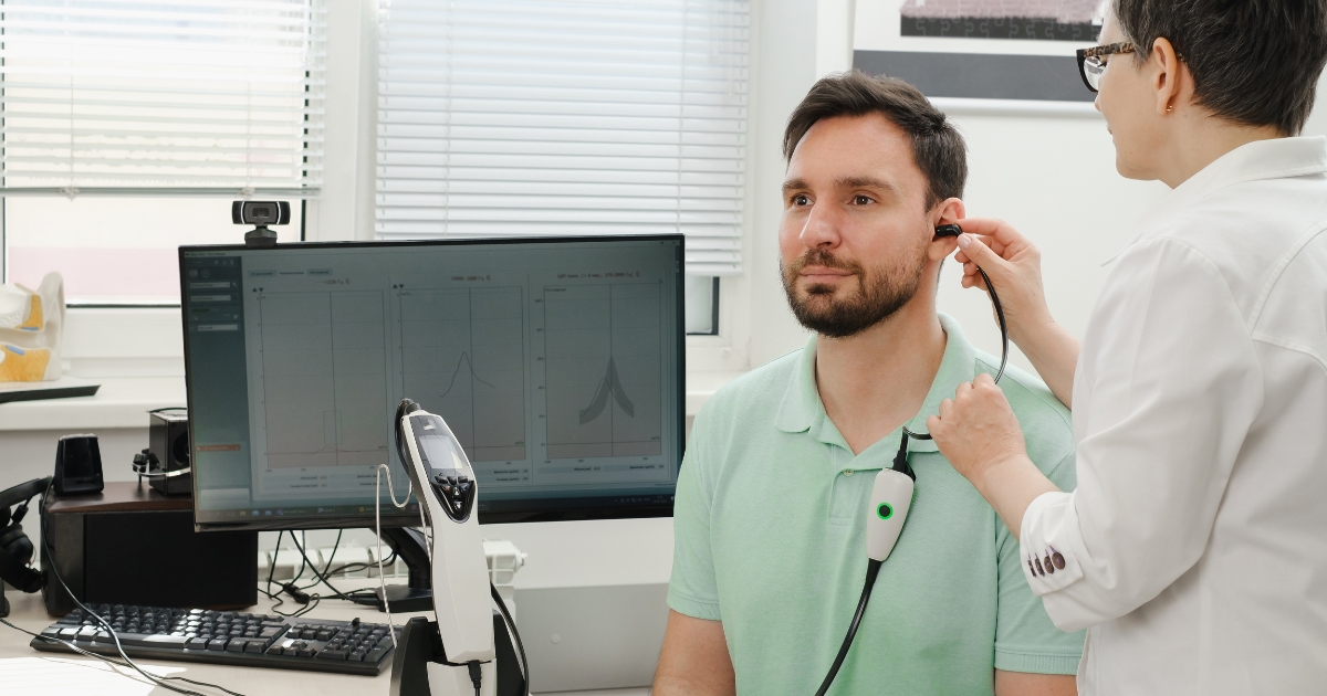 Audiologist performing a hearing test using advanced equipment in a modern clinic.